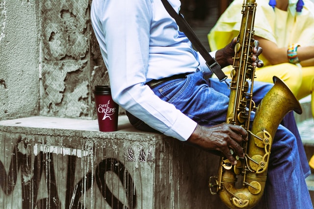 man playing saxophone in the street